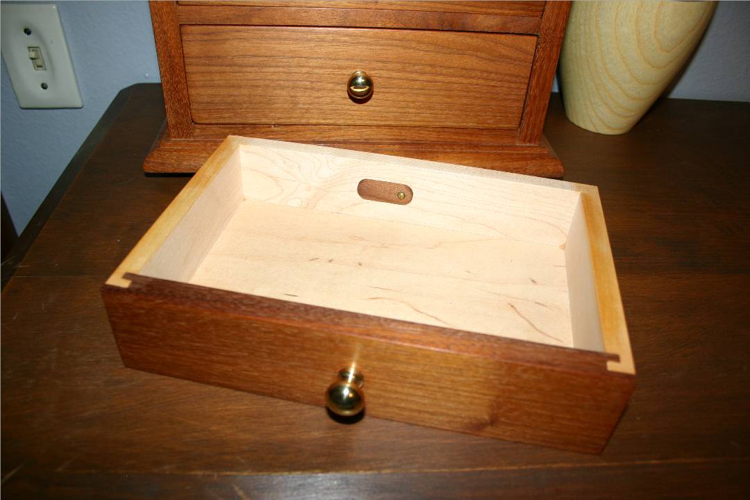 Small walnut tab at back of each drawer.